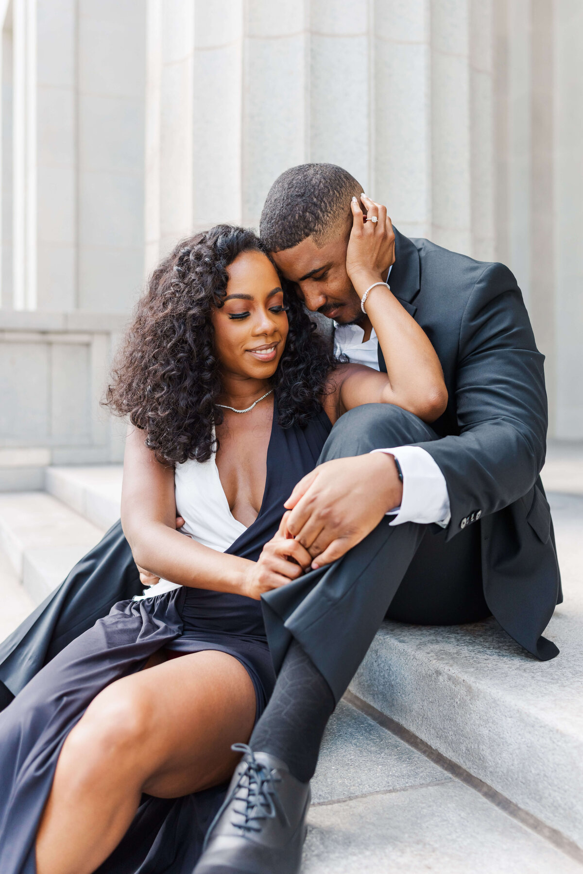 a cuple sitting don on stairs, while hugging