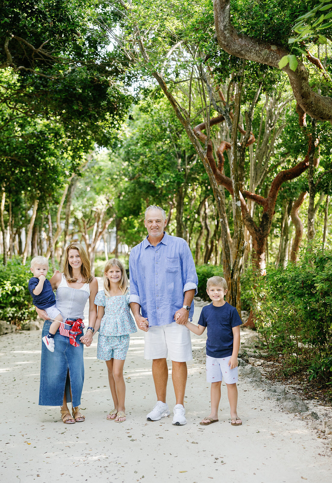 A loving family smiles together in an outdoor setting during a Florida Keys family session with Claudia Amalia Photography.