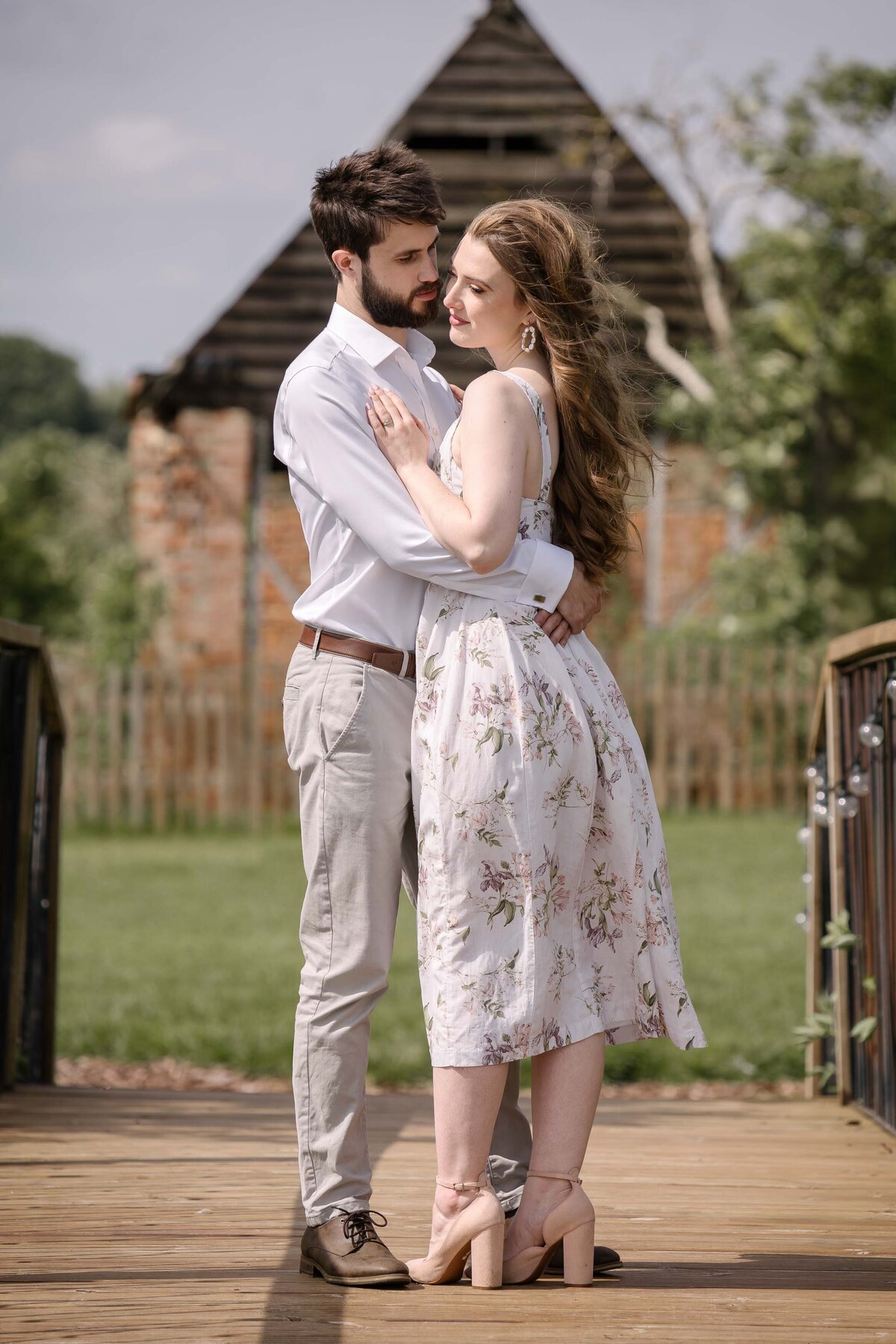 An engaged couple hugging on a bridge at a cambridgeshire wedding venue