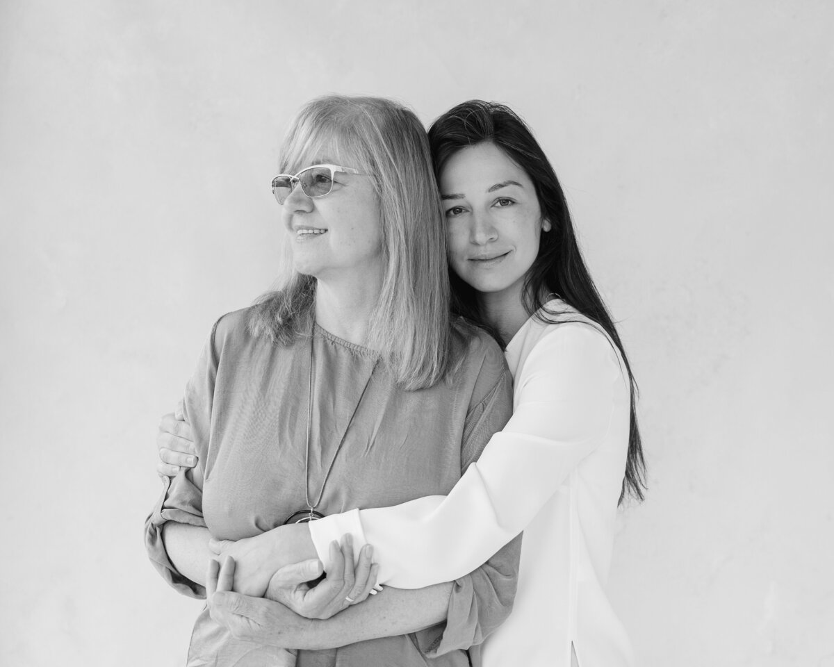 Daughter embraces her mother in  studio portrait