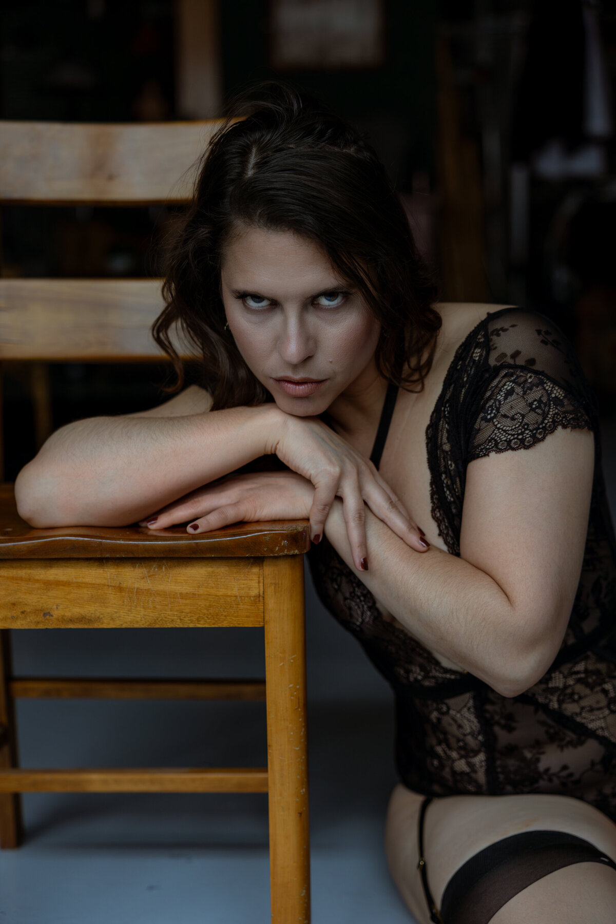 Femme en sous-vêtement de dentelle noire appuyée sur une chaise Photo Boudoir