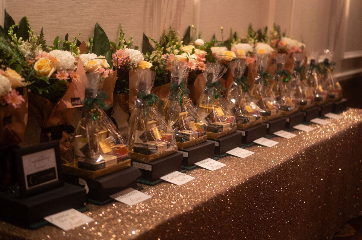 Sparkly tablecloth with awards lined up on a table with flowers for the  Business Excellence Awards in Stratford Ontario
