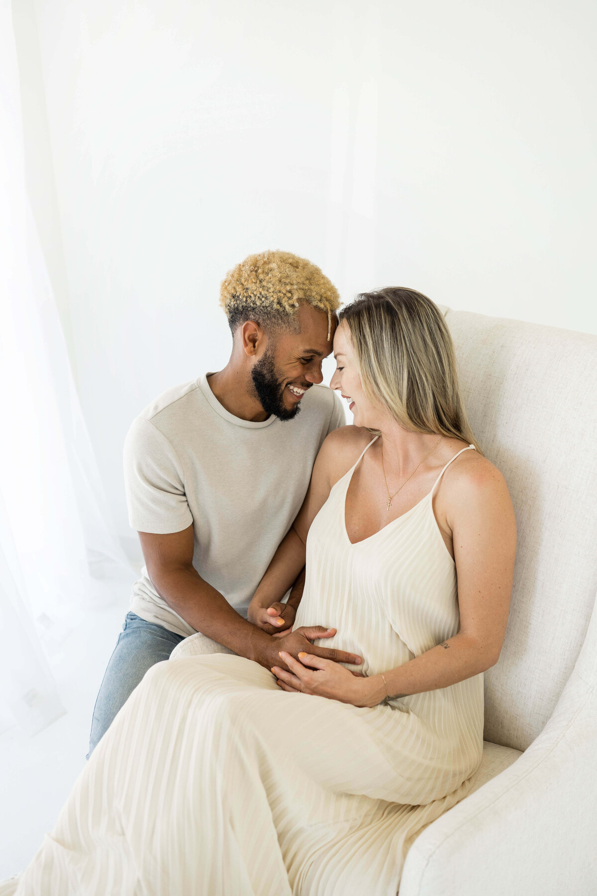 mom to be and dad to be laughing together as they prepare to bring their newborn into the world in their oklahoma home