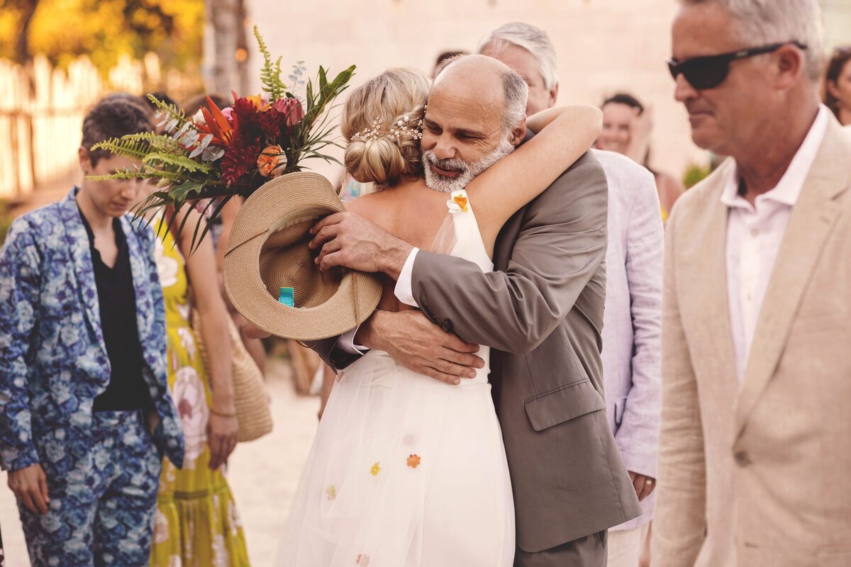 Guest hugging bride at Blue Venado Seaside Riviera Maya wedding