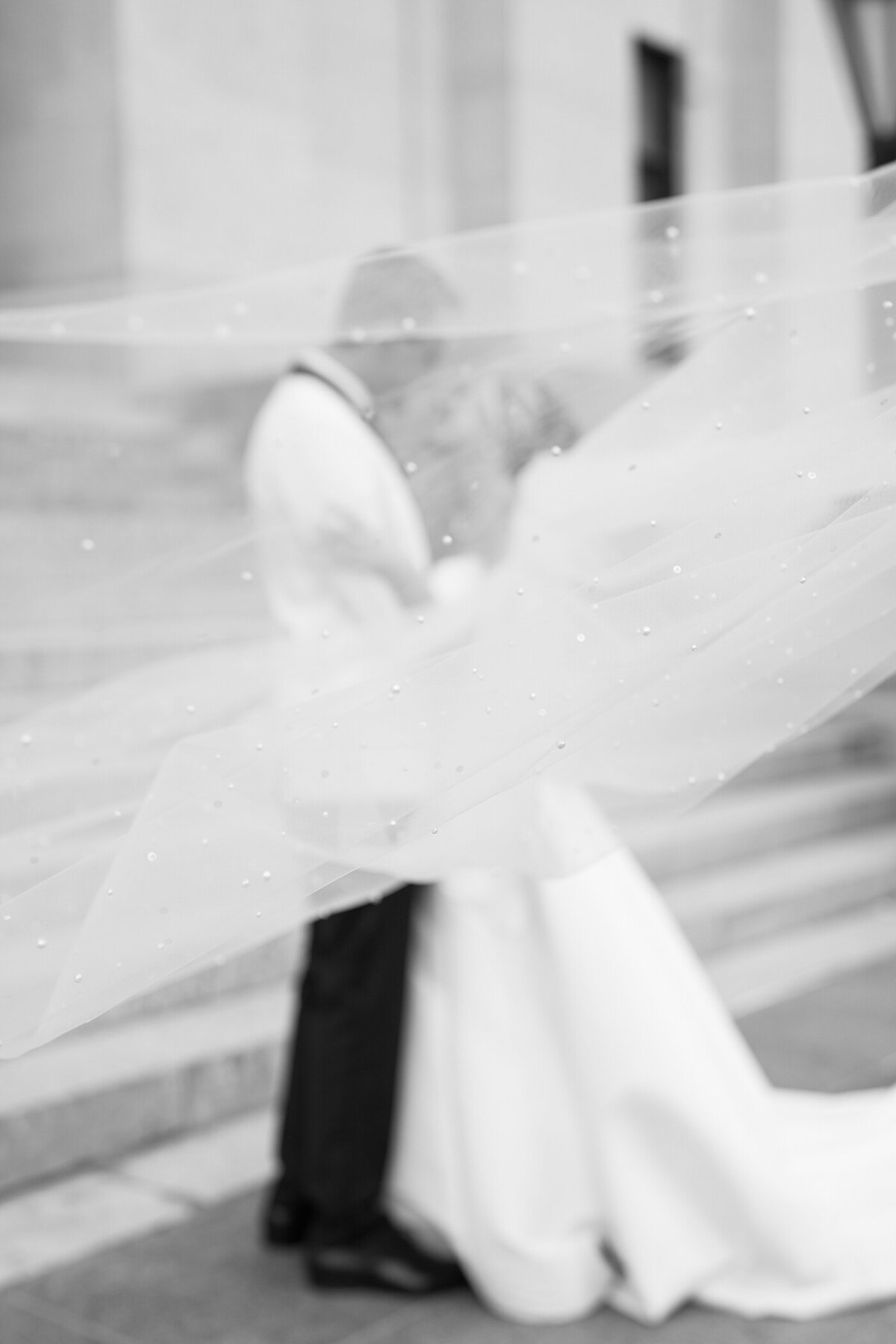 Columbus wedding  photographer photographs creative wedding photo with bride and groom embracing with a veil floating in front of them