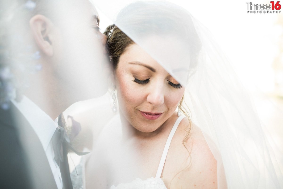 Groom gives his Bride a tender kiss under her veil