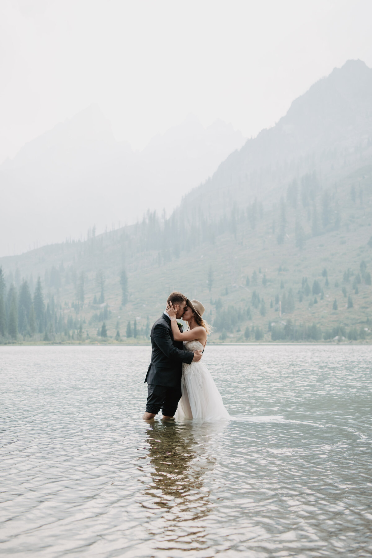 Jackson Hole Photographers capture bride and groom kissing in water