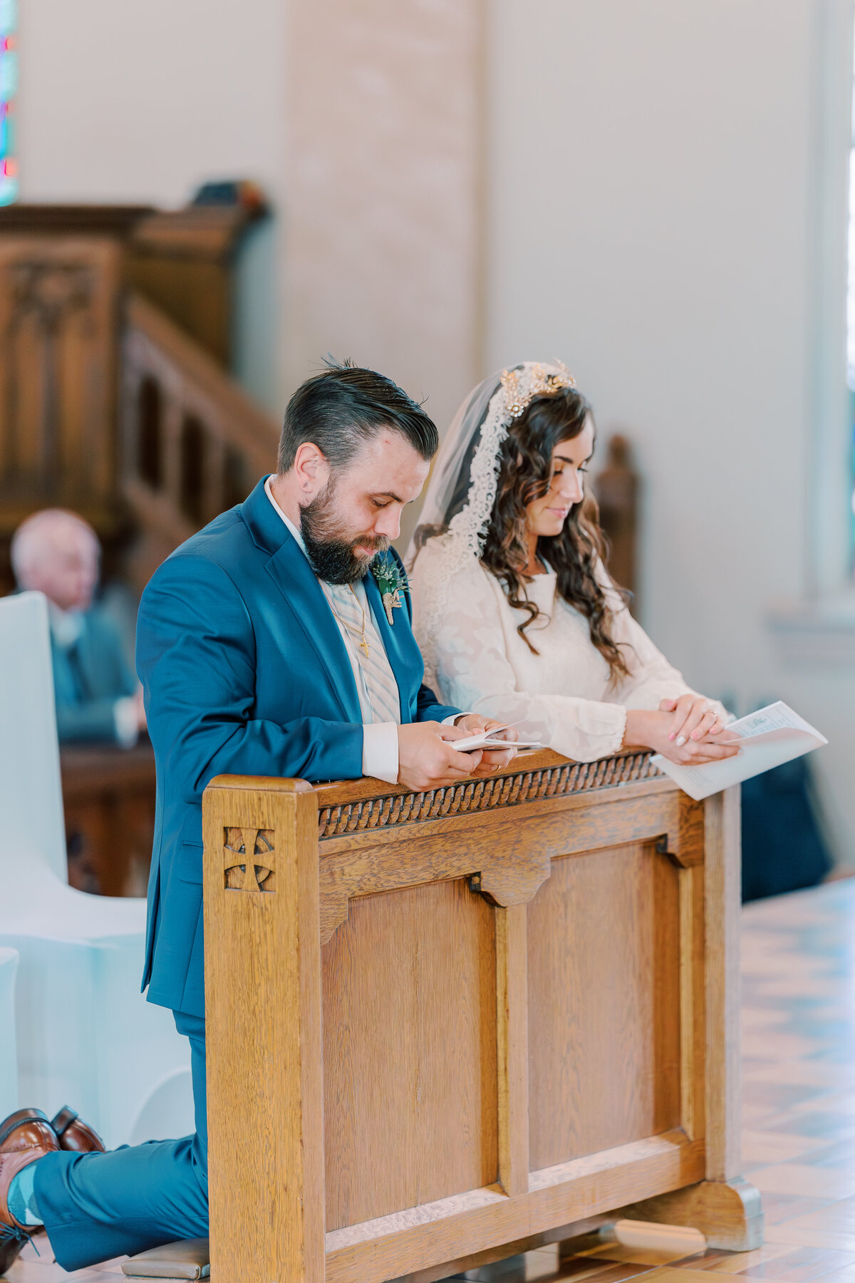 Bride and groom kneel and pray during wedding at Mary Holy Angels in Sidney, OH