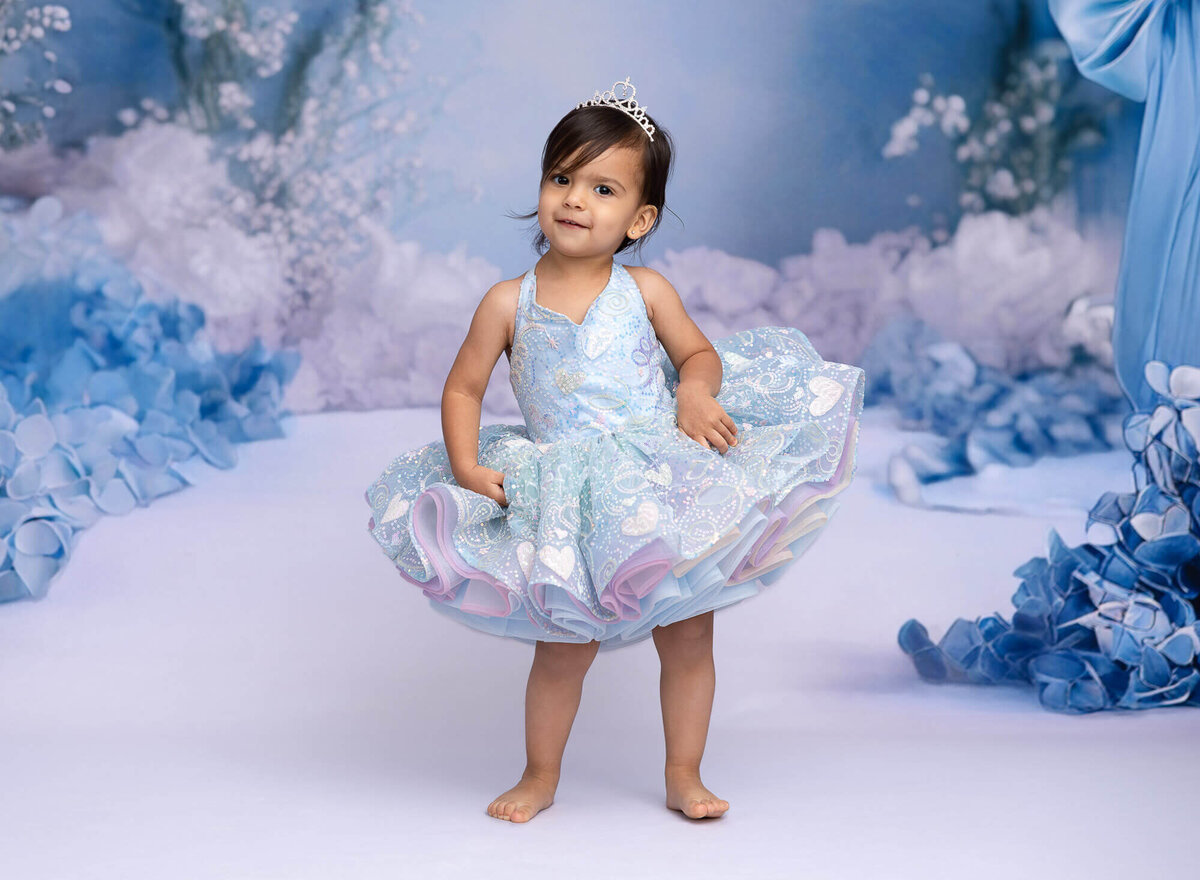 child in blue dressy gown celebrating birthday during photo session