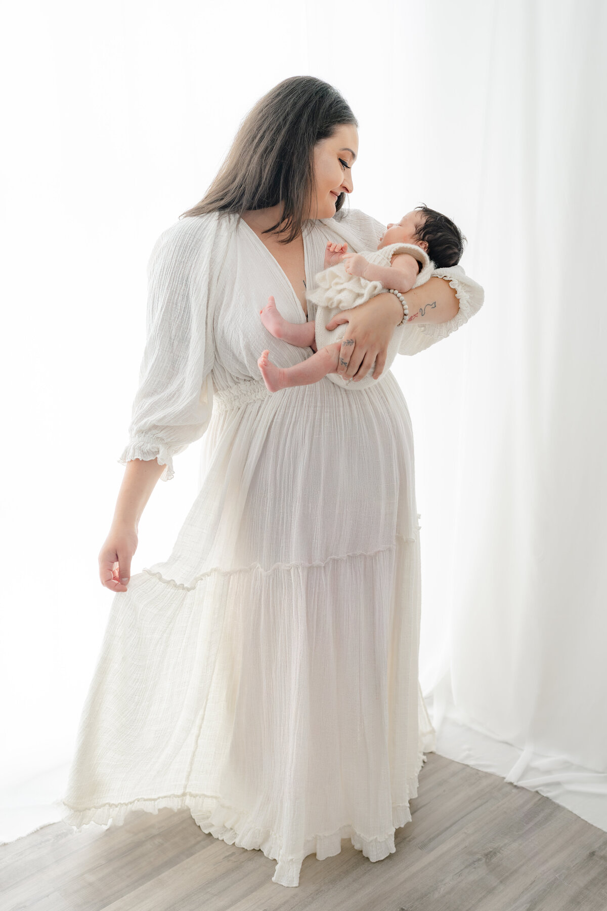 Mom holding baby during natural light Barrie newborn photography session 