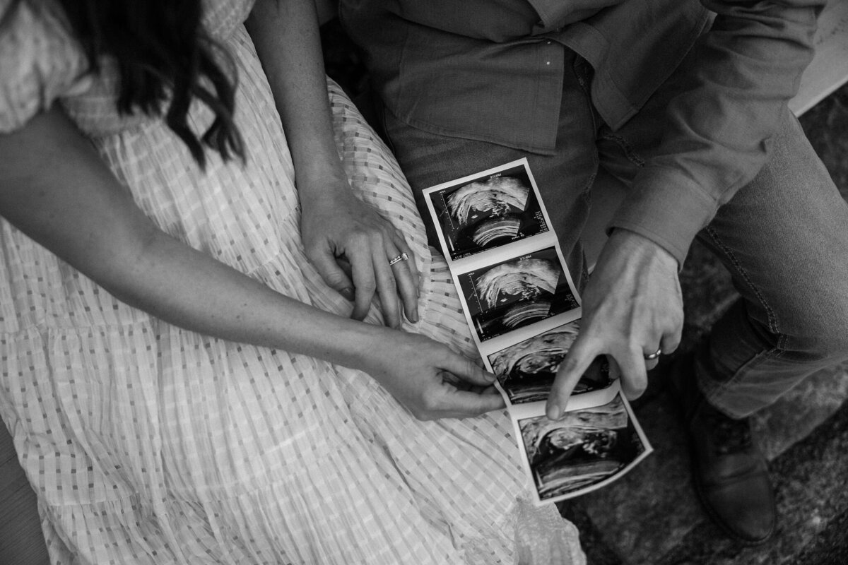 couple holding ultrasound photos