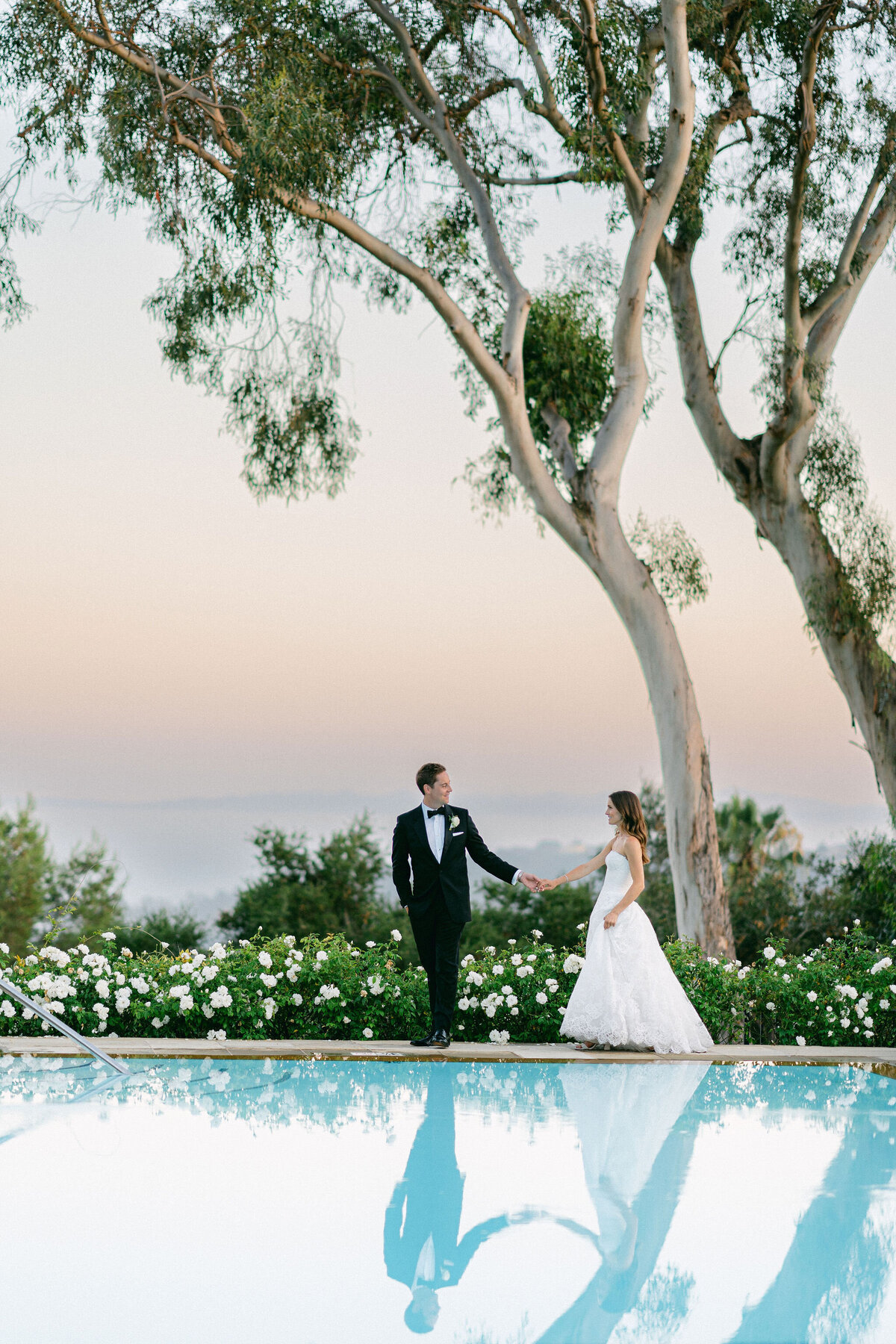 groom leading his bride at the end of the pool at the Belmond El Encanto in Santa Barbara