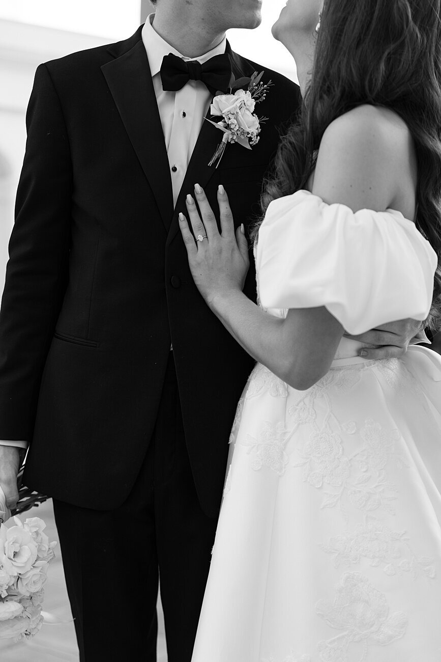 bride and groom hug with her hand on his chest