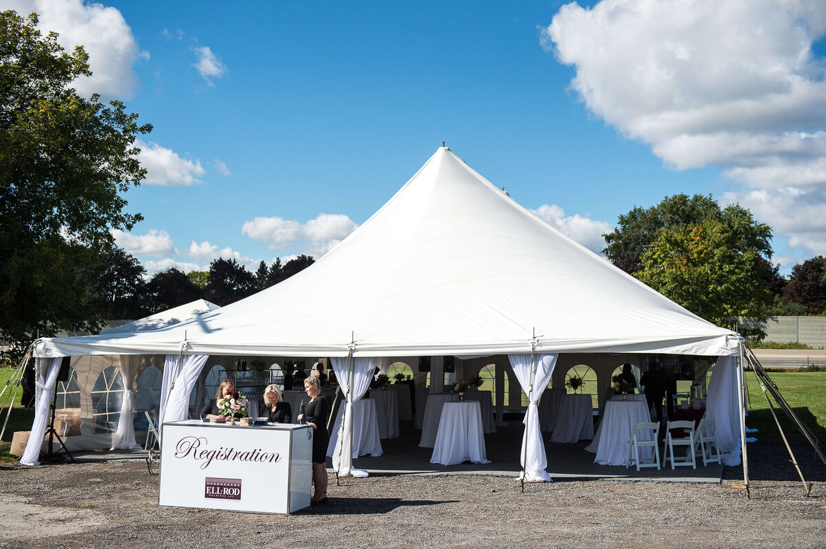 Ottawa event photos showing the registration team in front of a white tent for an anniversary celebration.  Captured by JEMMAN Photography COMMERCIAL