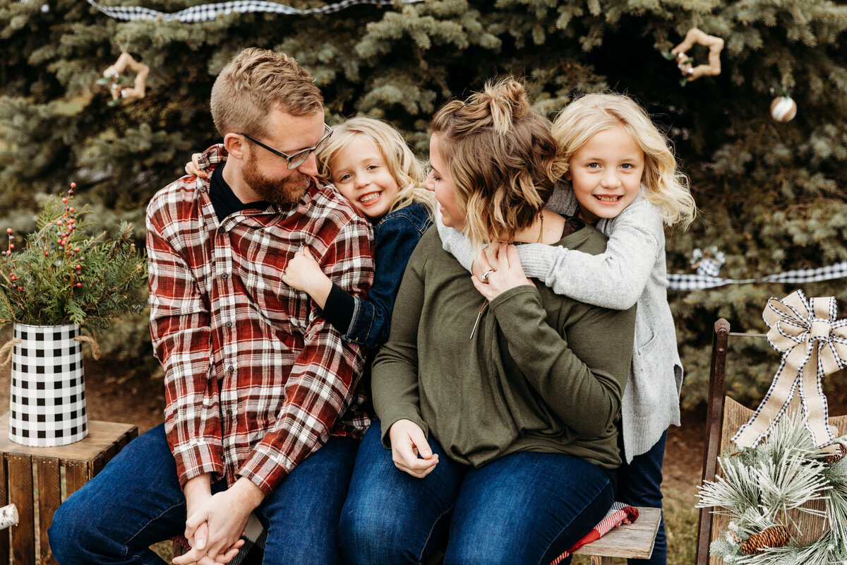 Daughters hugging parents and enjoying a moment together during family photos