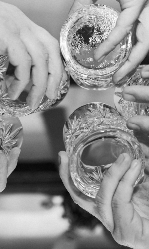 Close-up of wedding guests toasting with crystal glasses at Baker's Cay, captured by Claudia Amalia, a wedding photographer in Miami.