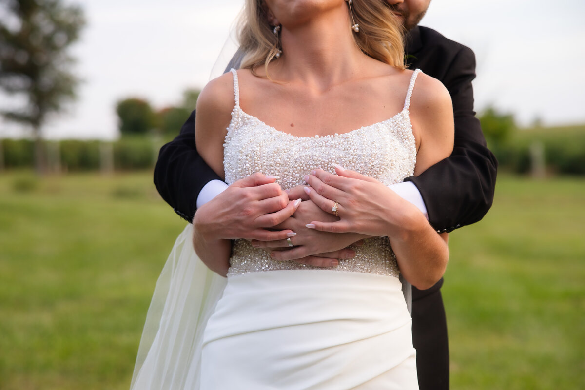 groom hugging bride from behind