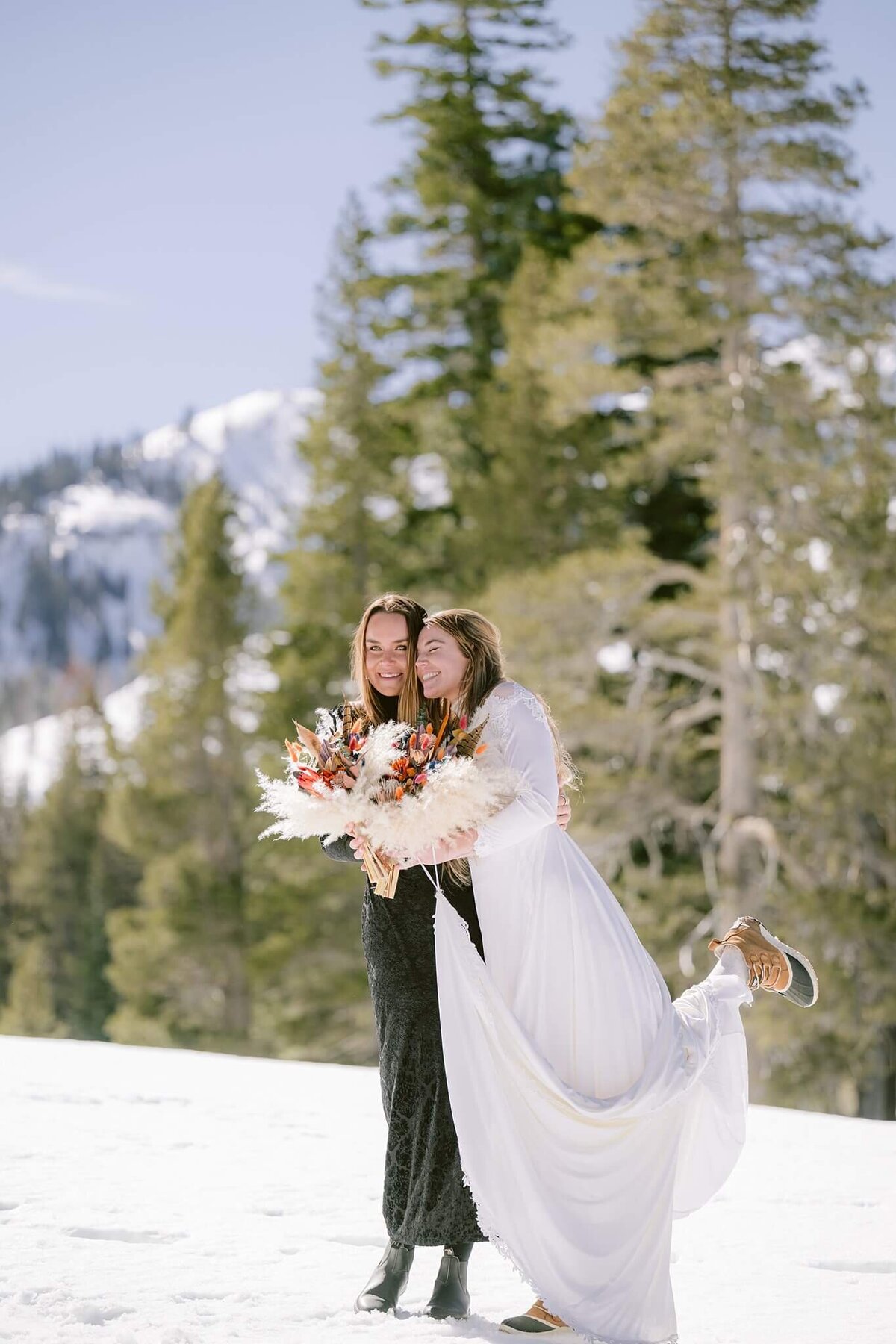 bride and sister laughing after Tahoe elopement in winter candid laughs