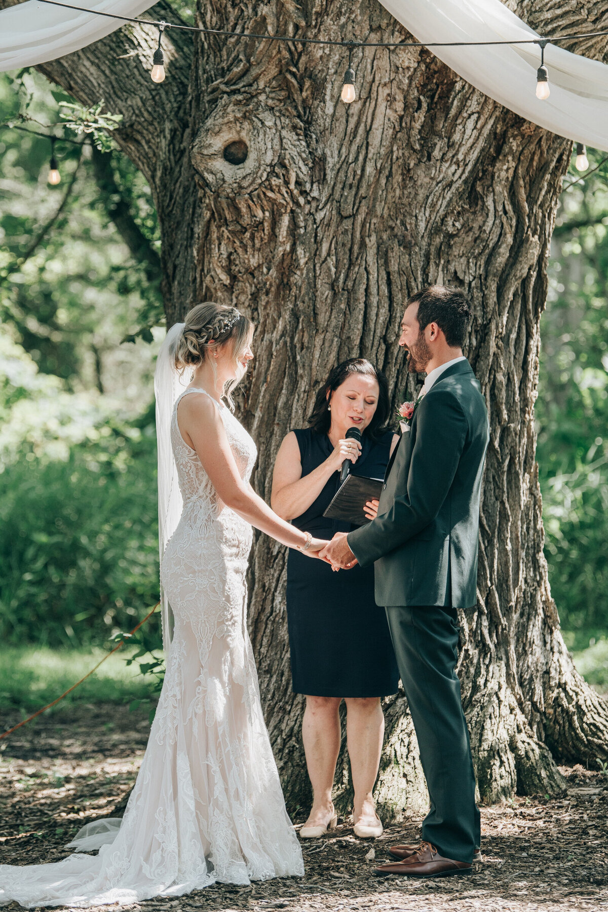 Bride and groom saying their wedding vows under a grand willow tree