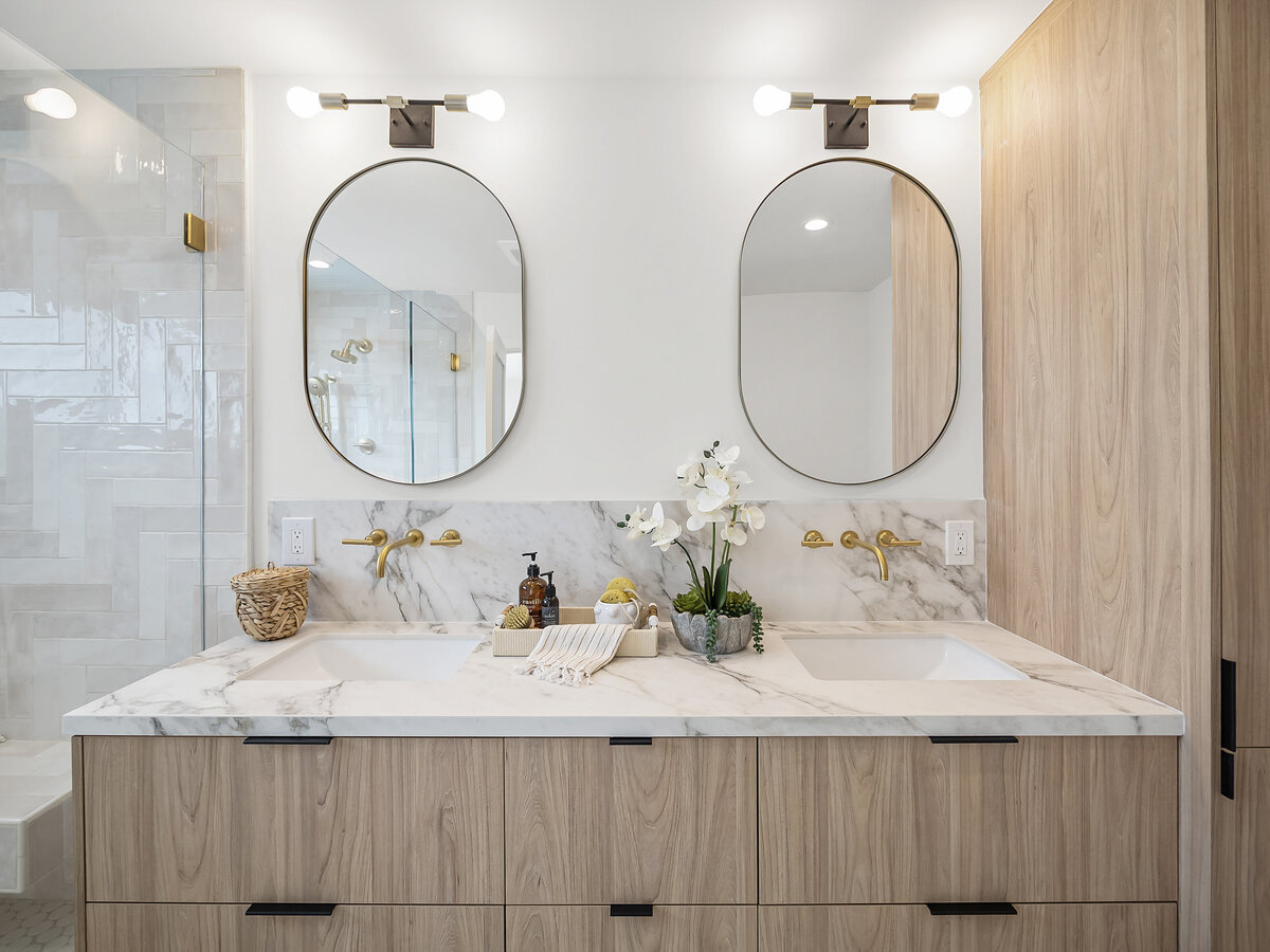 Bathroom interior design having 2 sinks and oval mirrors