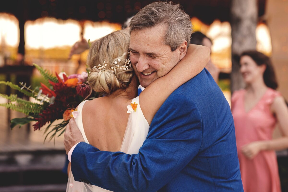 Father hugging bride after ceremony at Blue Venado Seaside Riviera Maya wedding