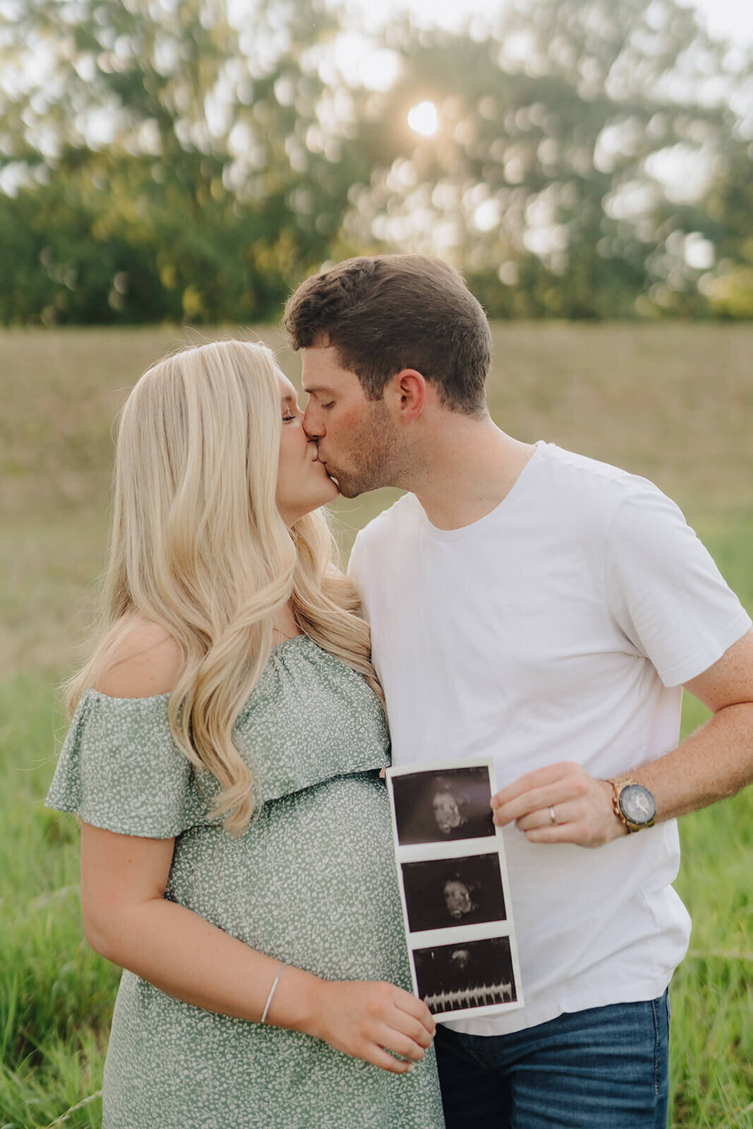 Couple holding baby scan photos for  maternity session in Finger Lakes, New York