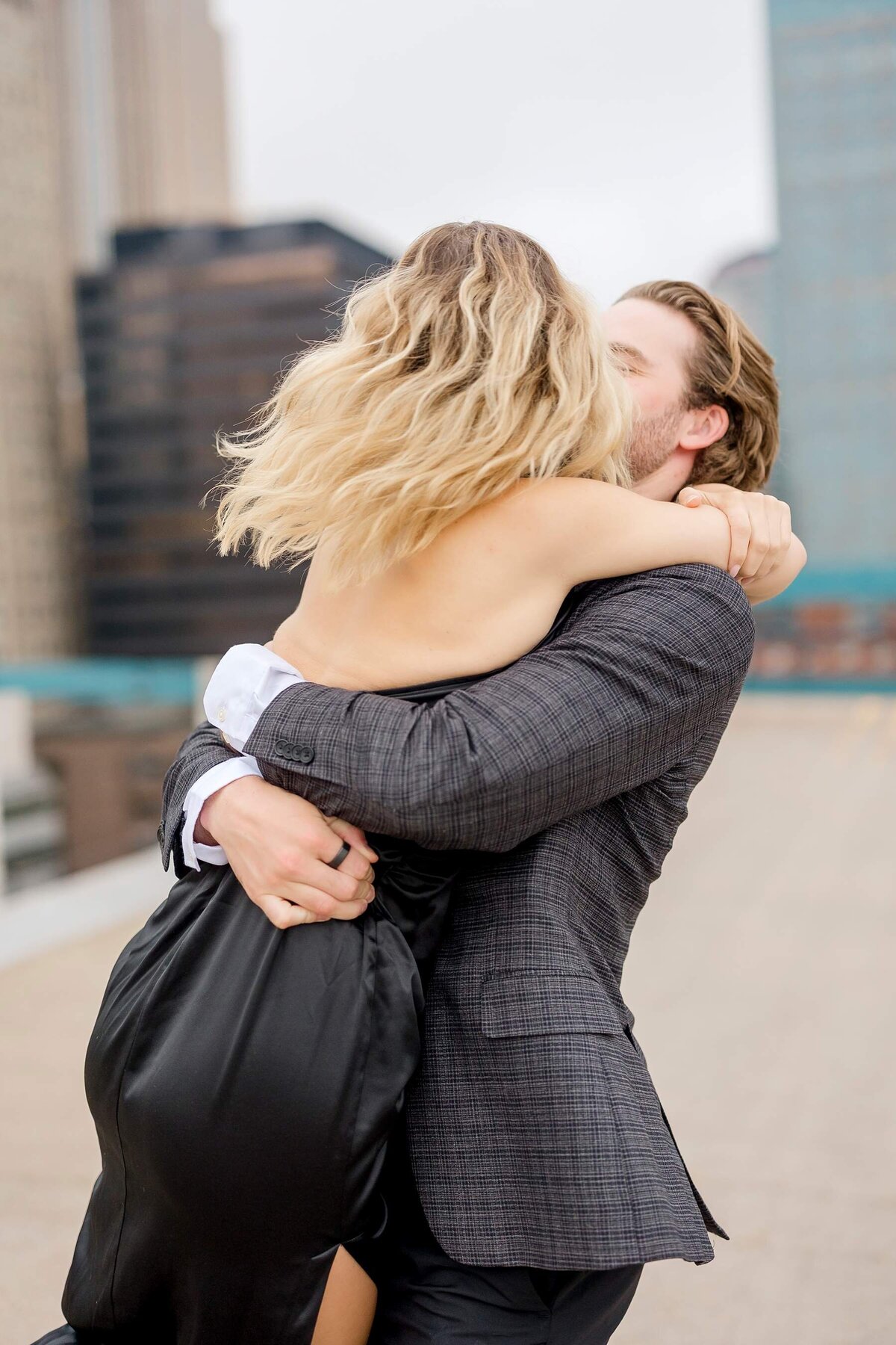 Romantic Minneapolis engagement session captures a couple's love in motion, embracing passionately in the heart of the city with a beautiful blur effect