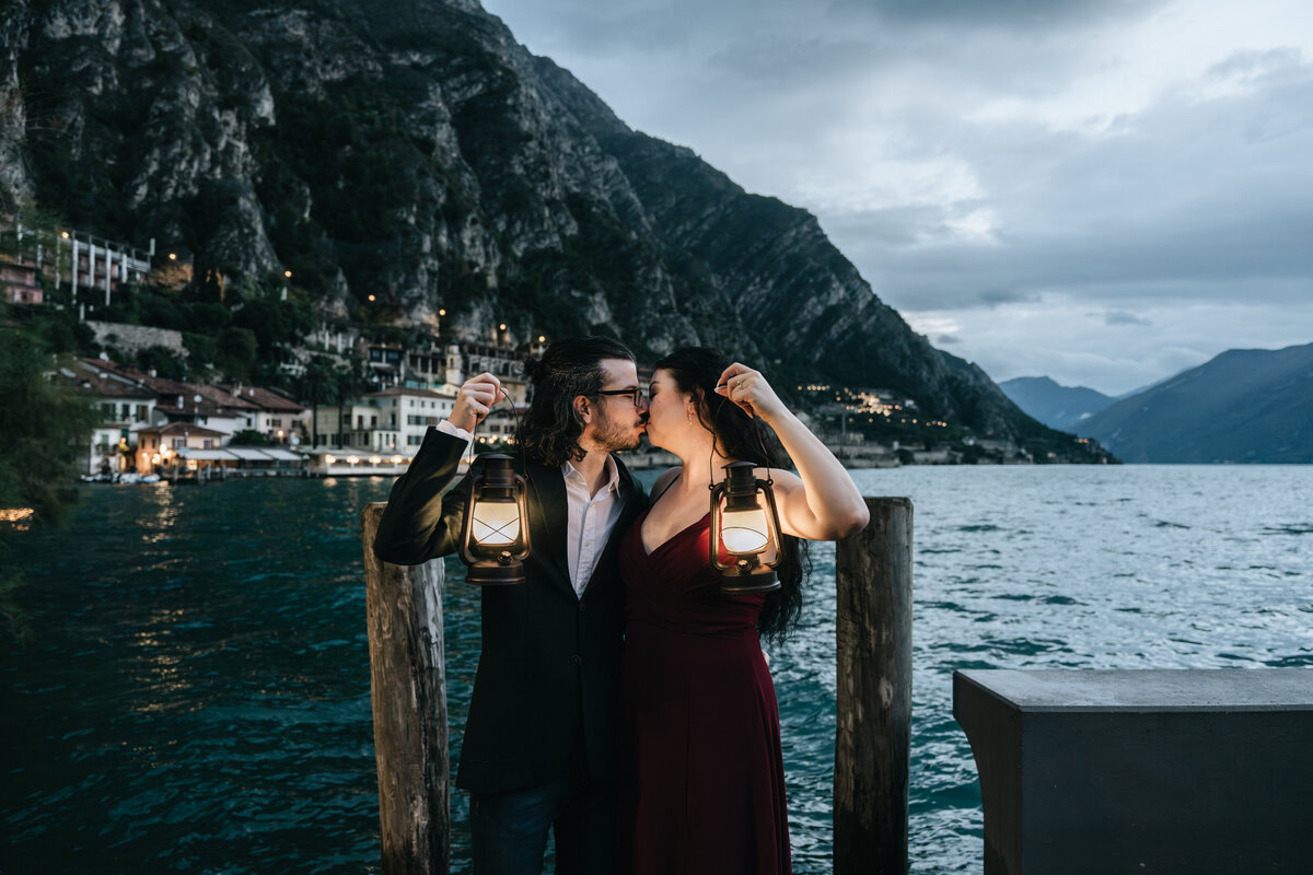 Couple holding lanterns at Lake Garda during evening session