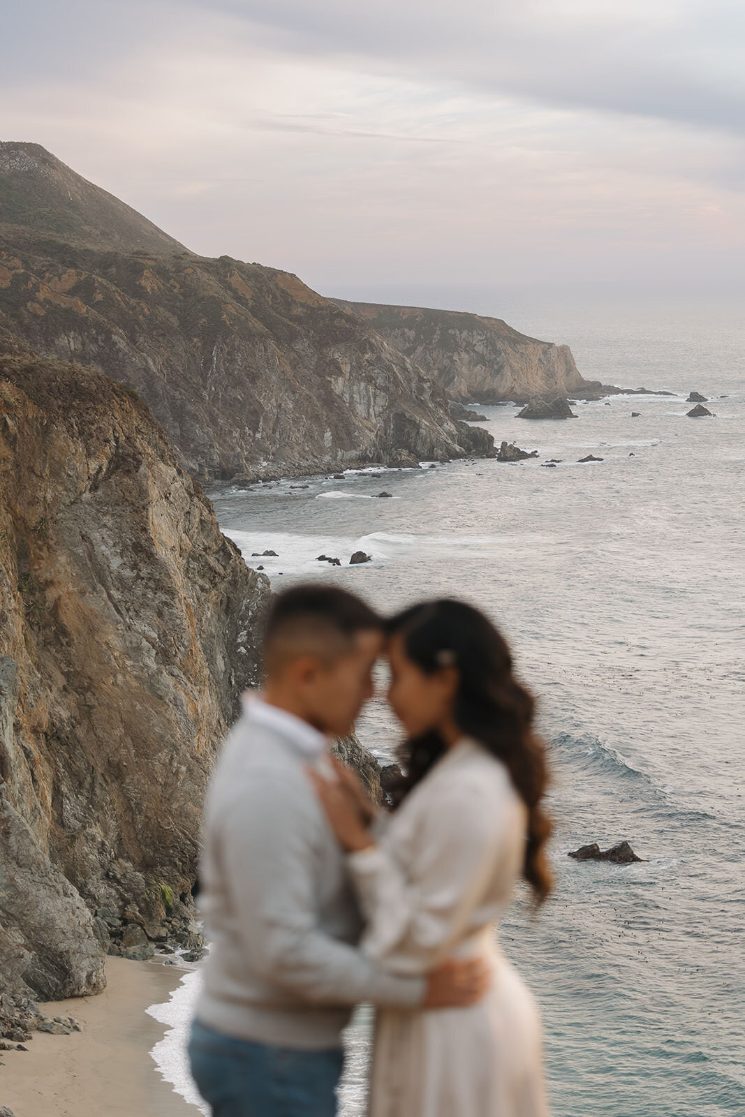 Couple embracing on the cliffs above the ocean