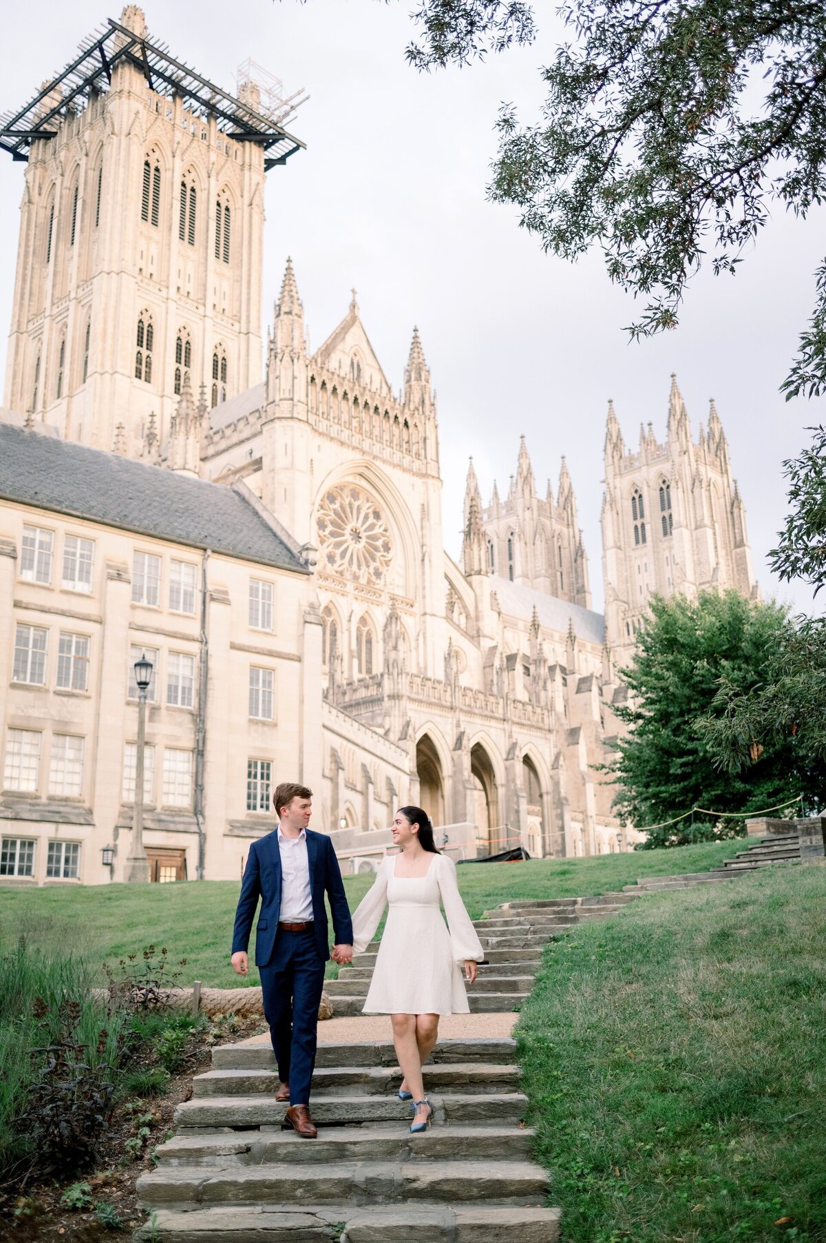 a couple walking down steps outside of the National Cathedral