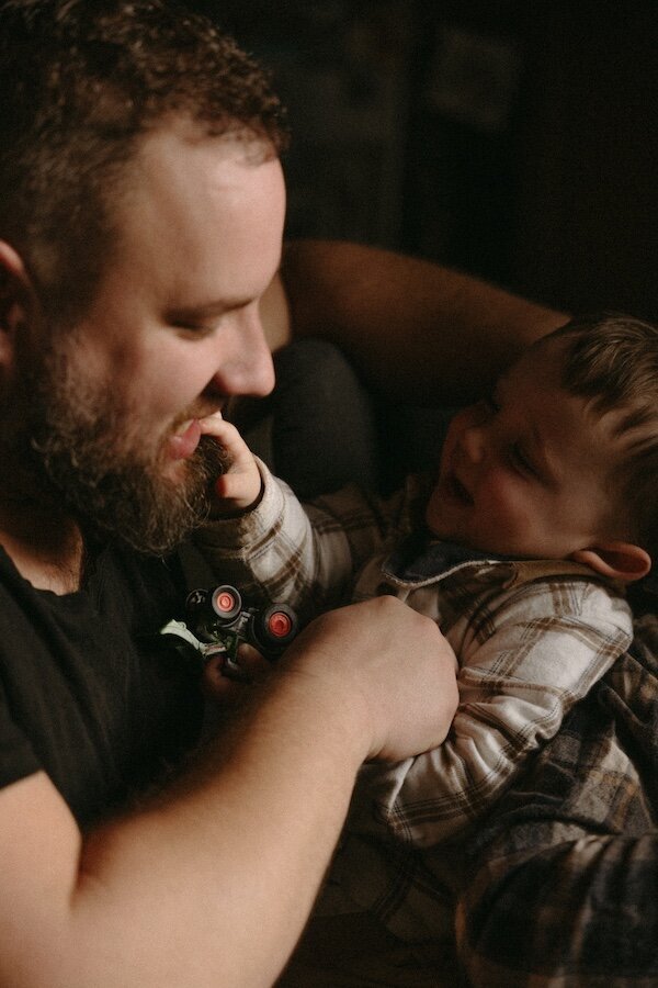 Éclats de rire entre père et fils, complicité et instants précieux. Par Kamescop, shooting photo familial à domicile.
