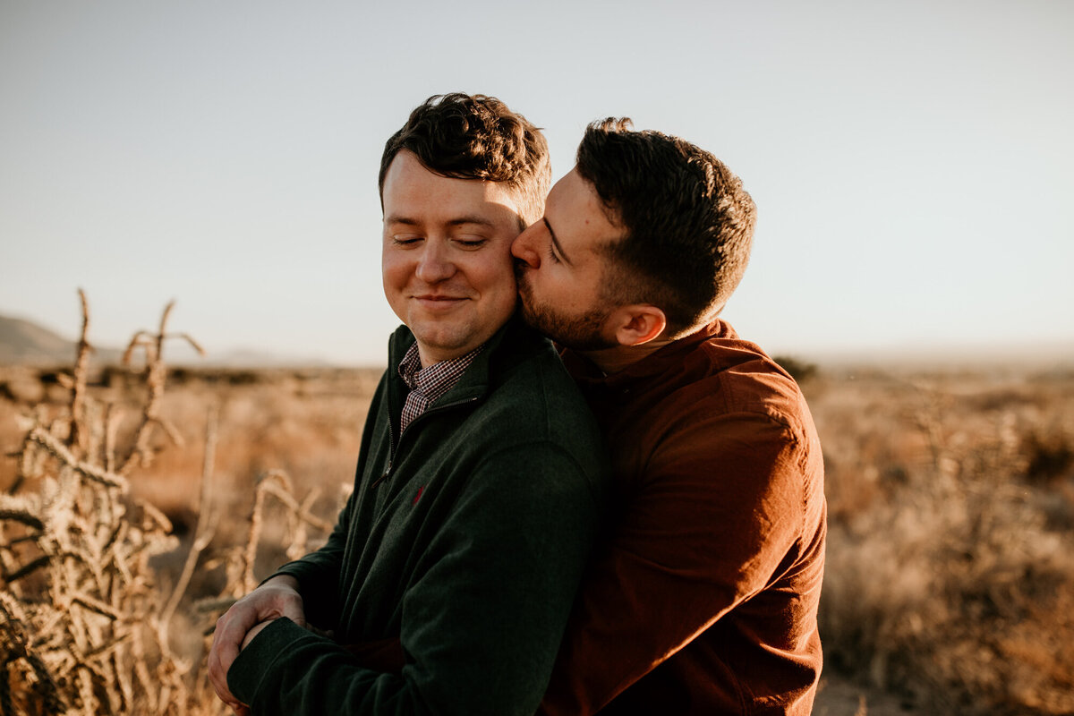 man kissing fiancé from behind
