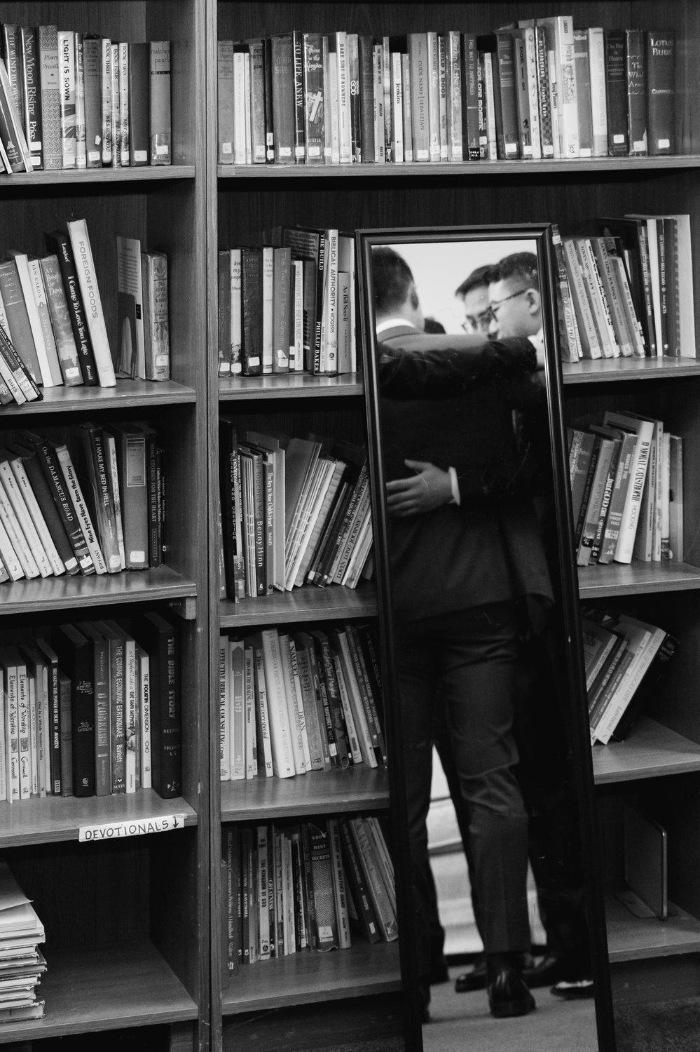 photojournalistic style black and white men in church library praying before ceremony