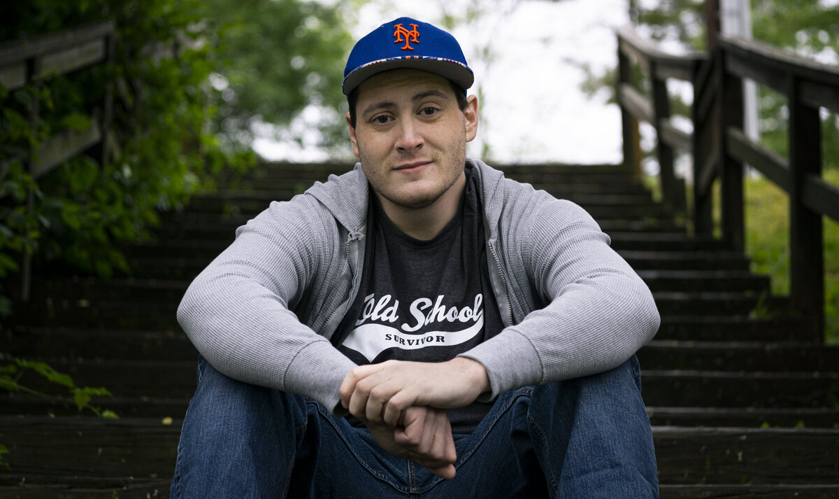 Headshot of a man sitting on stairs in a park