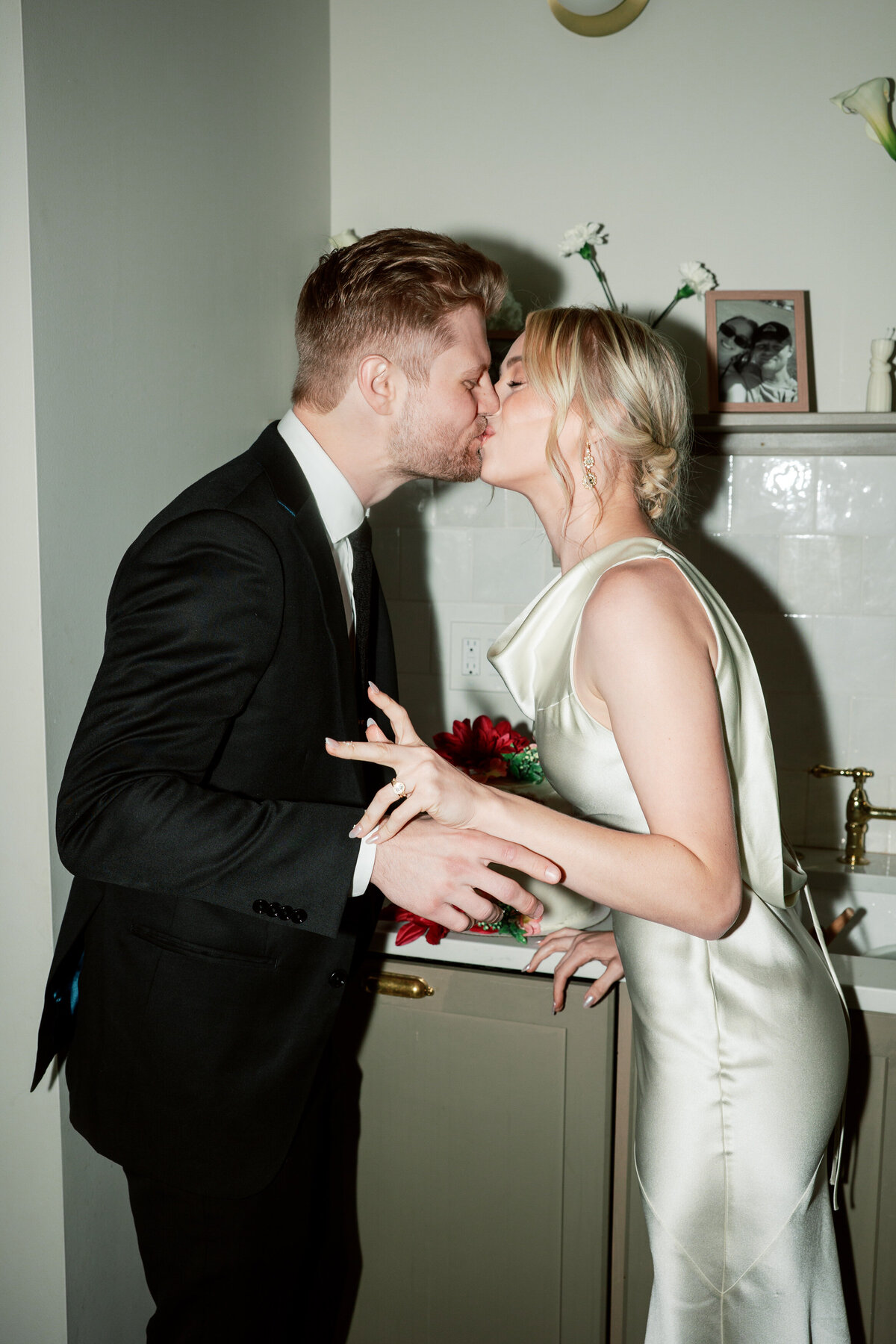 Bride and groom kiss after cutting cake at Dayton, Ohio wedding, captured by a Philadelphia-based wedding photographer.