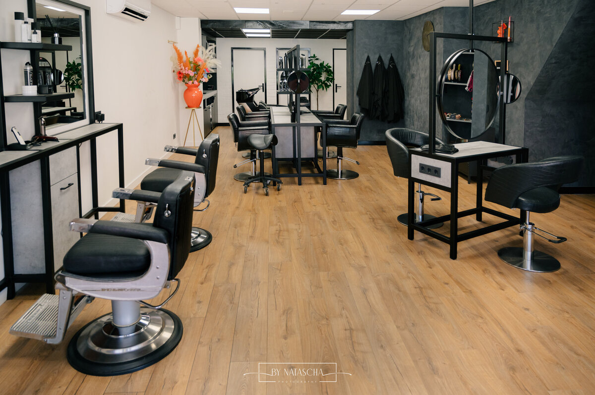 De salon van Haarstudio Heesch waarbij alle kapperstoelen zichtbaar zijn bij de spiegels en achterin de wasbakken om haren te wassen