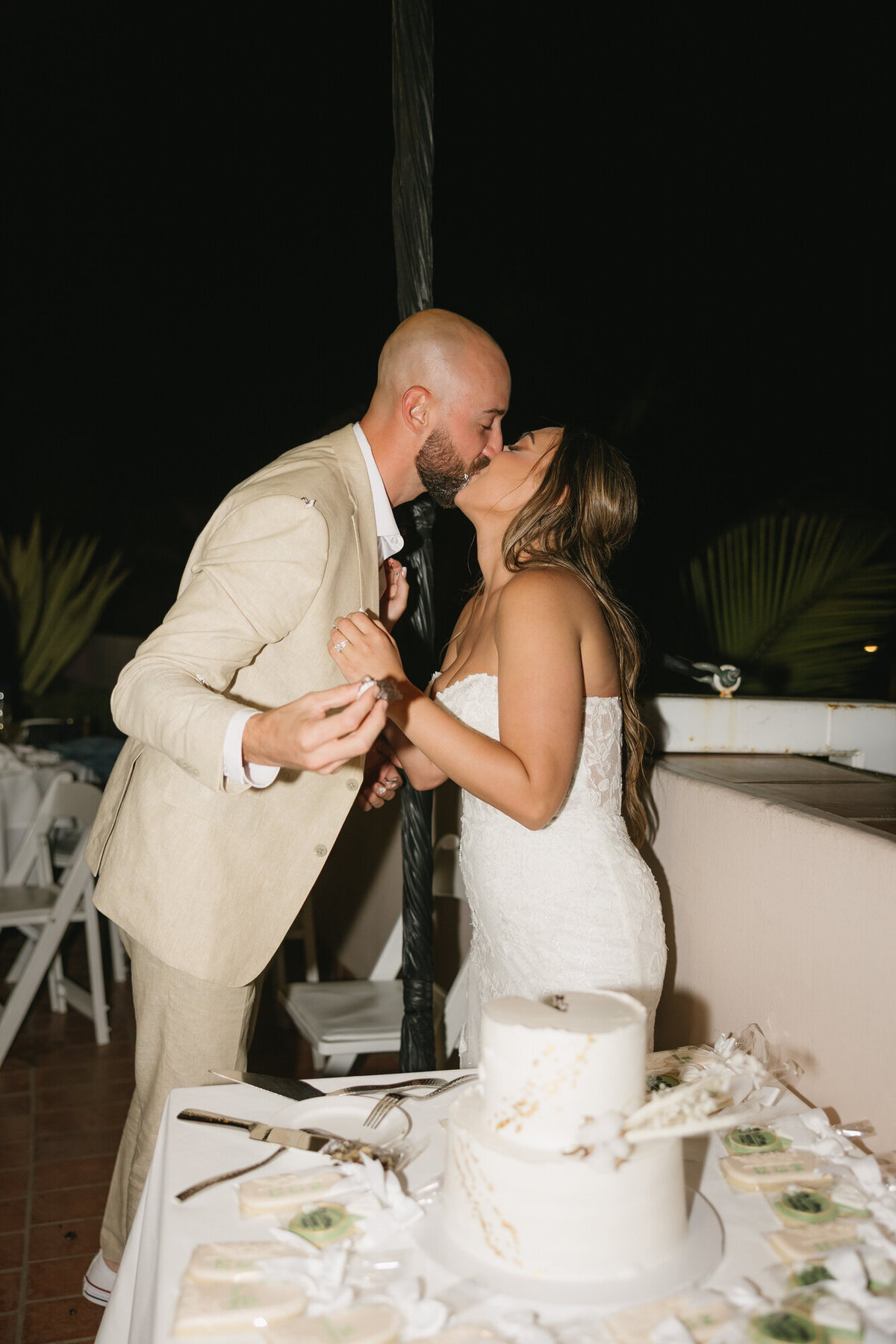 Bride and groom kissing during cake cutting at Hilton Beachfront Resort Santa Barbara