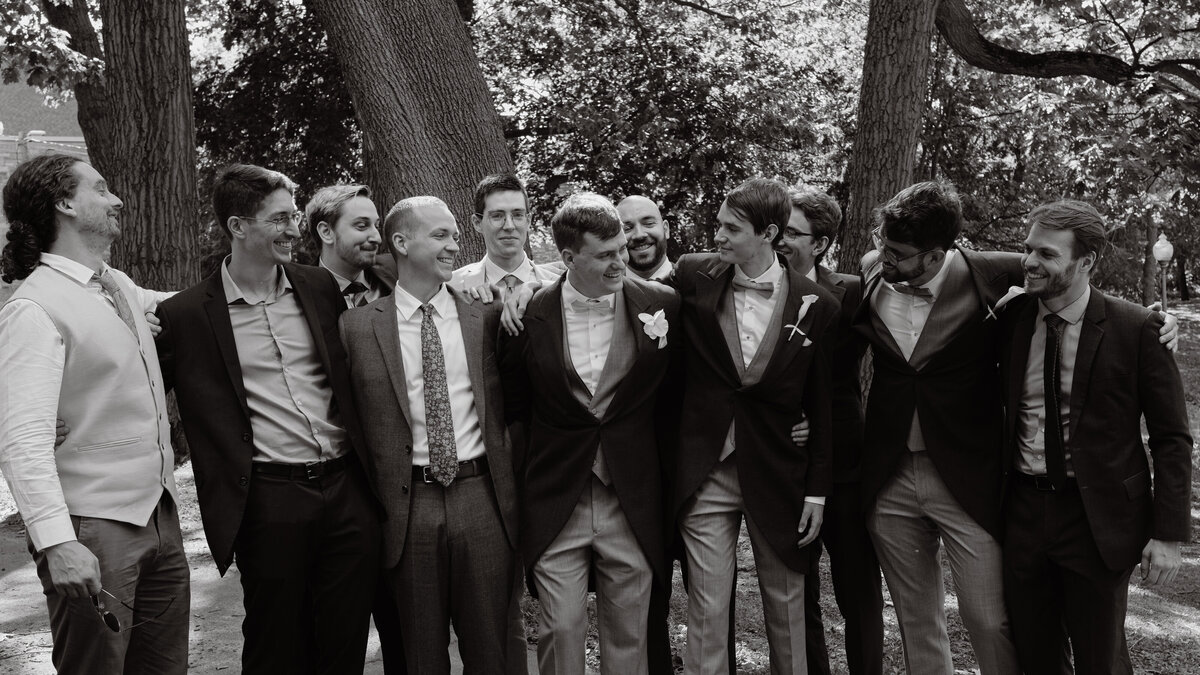 groom and all of his friends smiling with each other in nature