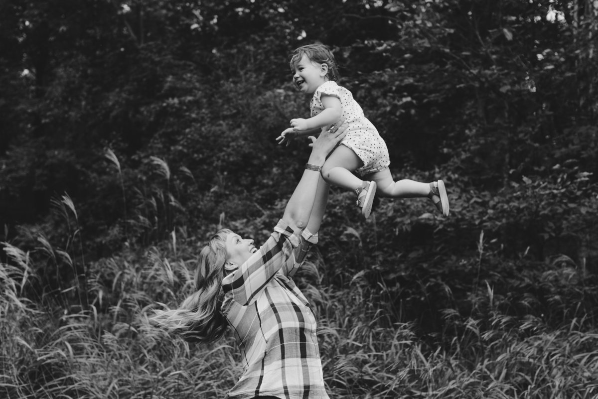 little girl being thrown up into the air laughing