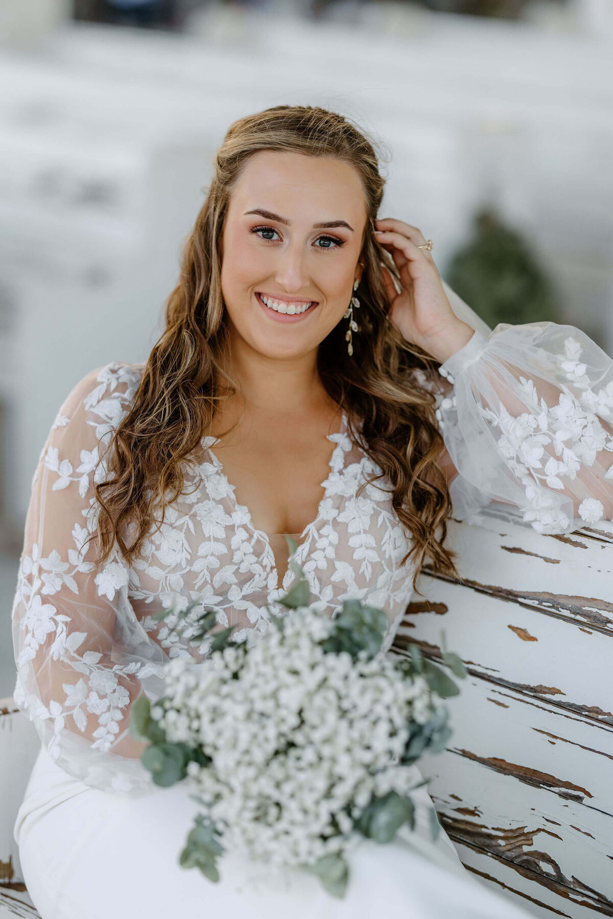 bride in vintage lace wedding gown sitting on wedding chapel pew