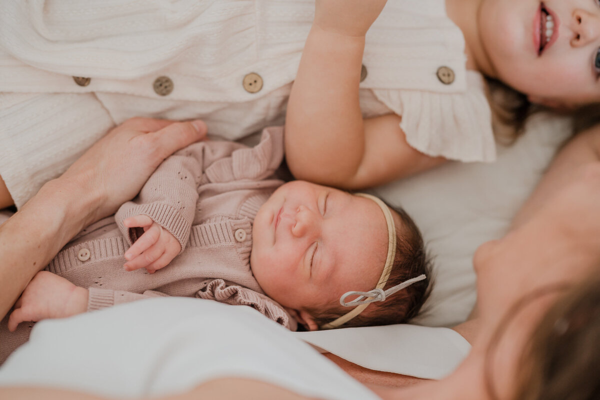 Close up of a baby in a family cuddle pile during lifestyle newborn pictures.