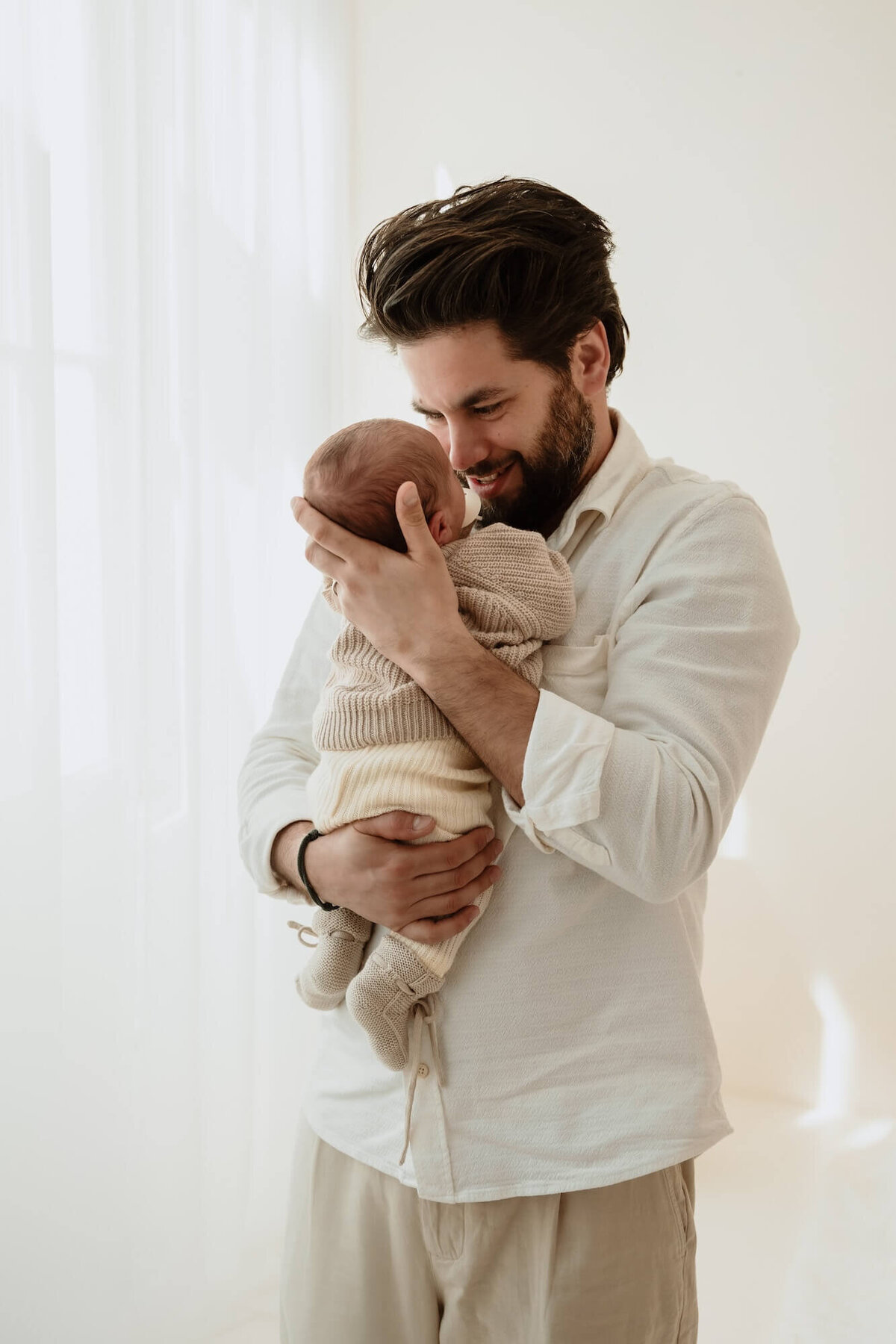 vader met baby in daglichtstudio tijdens newbornshoot