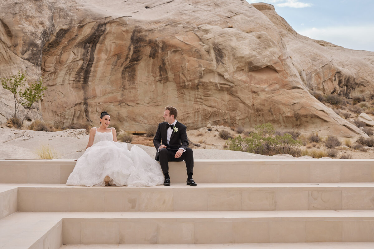 Bride and groom sitting on steps at Amangiri Utah