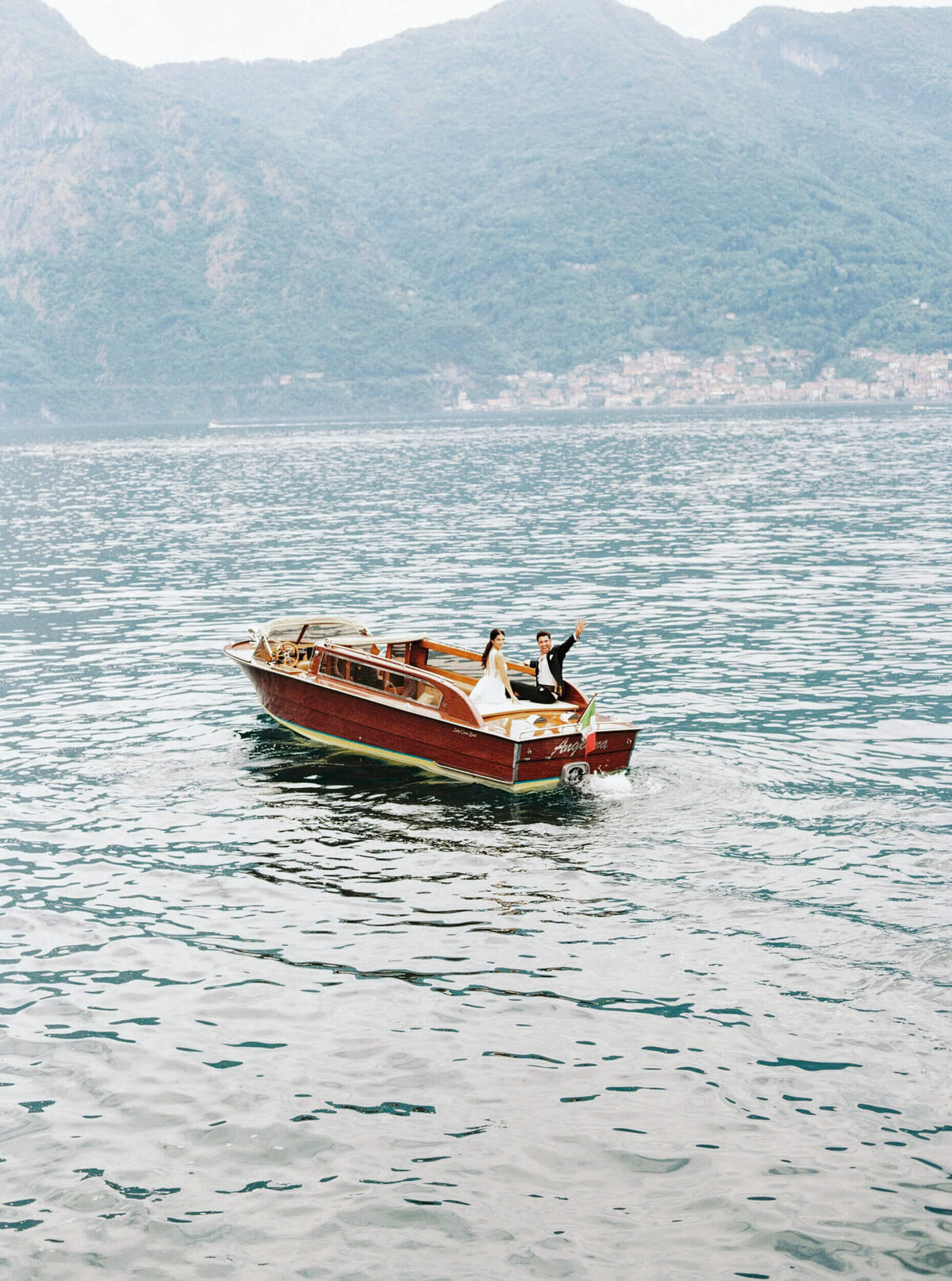 A wedding photo of the couple on a boat on the way to their wedding venue Villa Balbiano