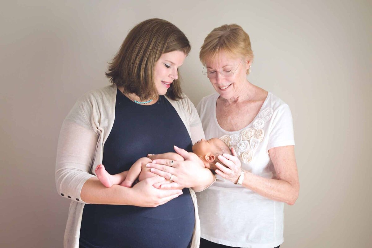 New mom with newborn and grandmother looking down at the new little boy in Columbia SC
