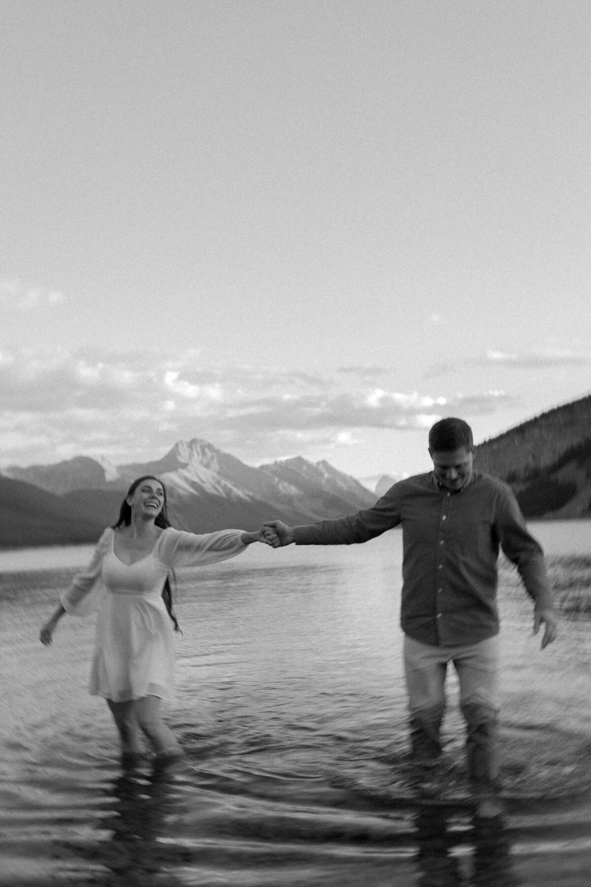 engagement photo of couple wading in a mountain lake near calgary