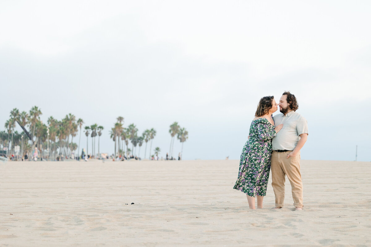 A couple leaning in for a kiss on the beach