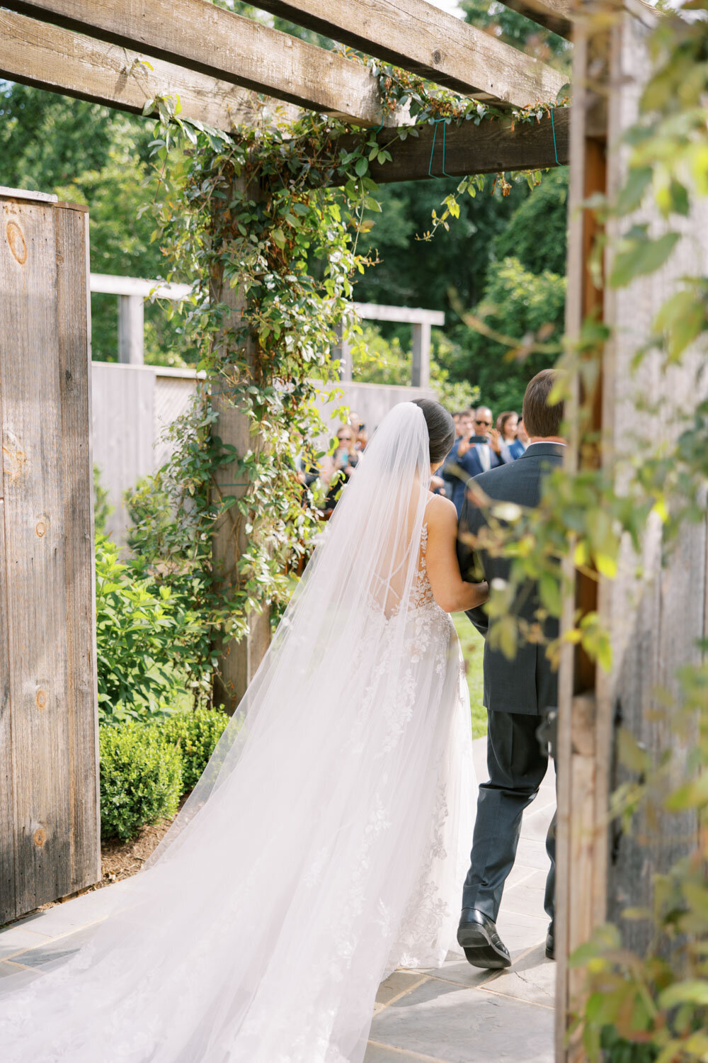 Back photo of bride and father walking