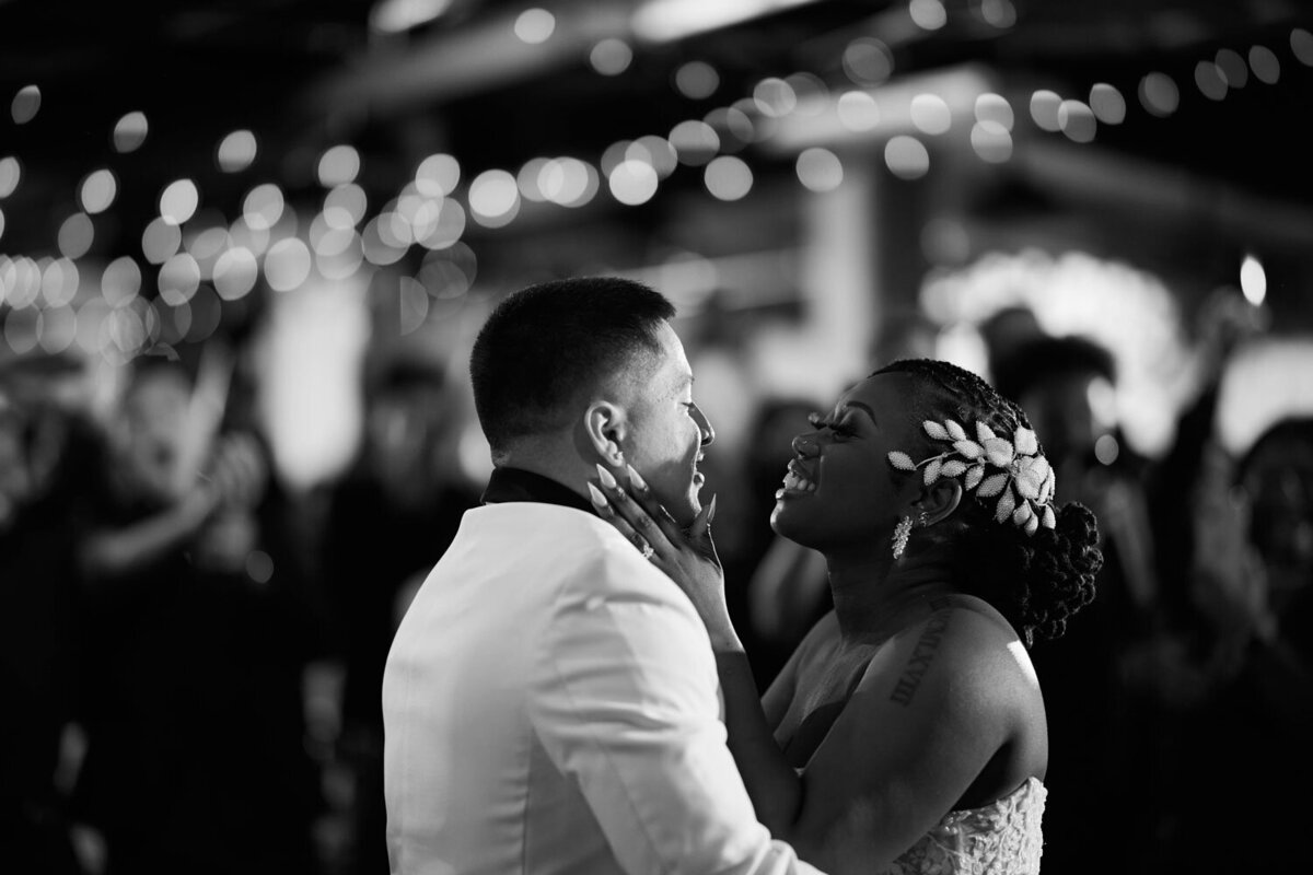 Bride smiling while dancing with groom