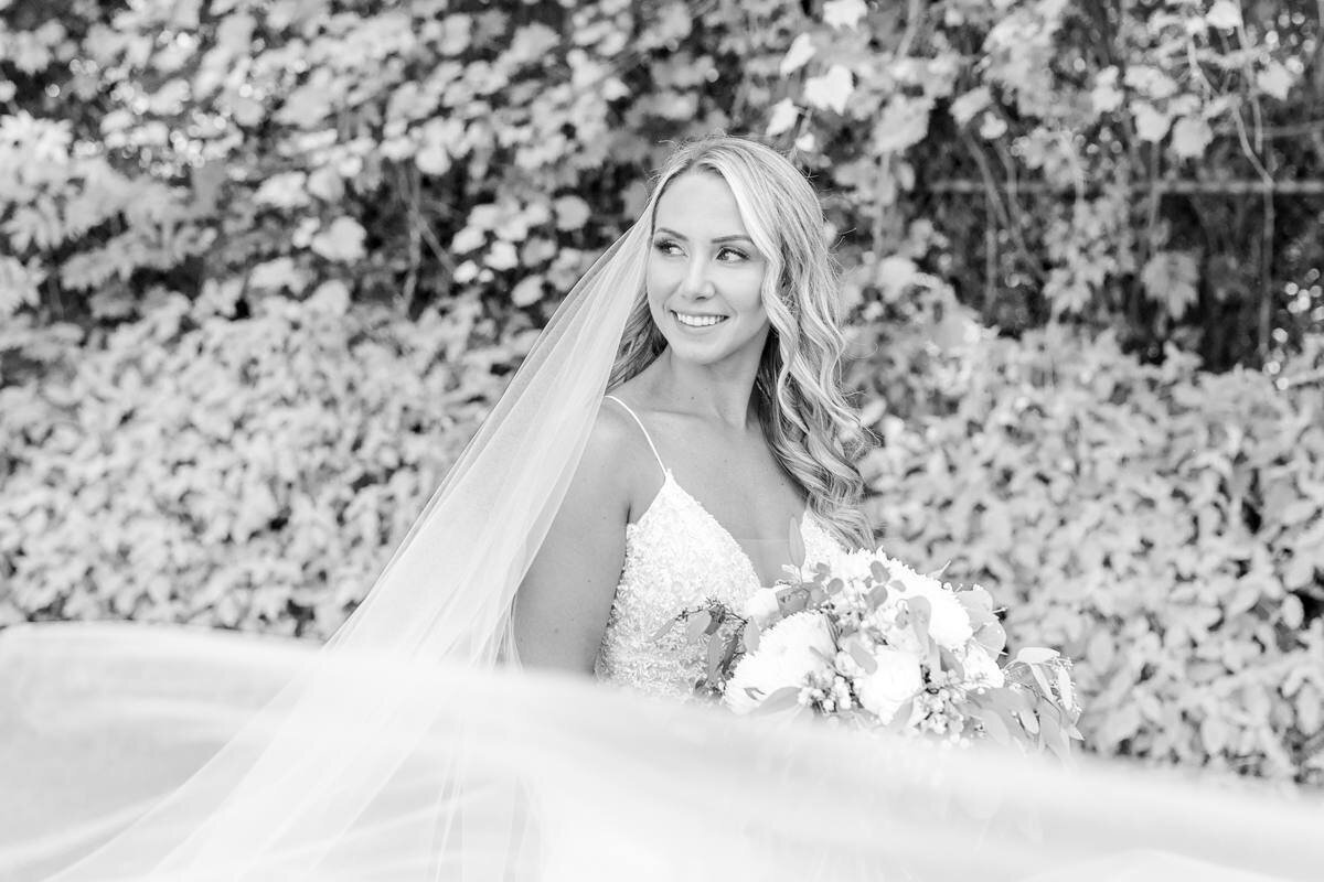 black and white photo of bride with long veil